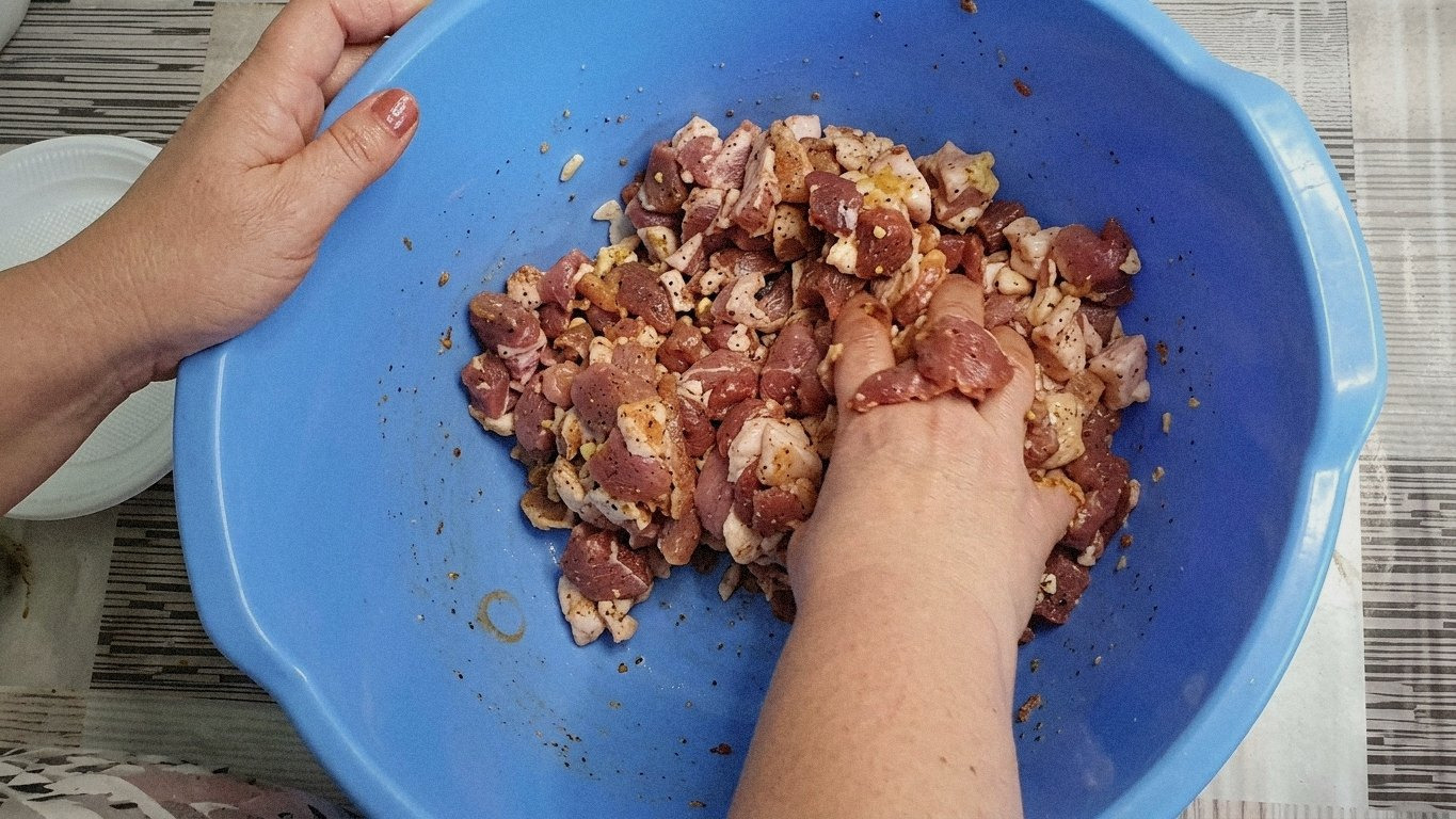 процес наповнення свинячих кишок м'ясною масою, видні вузлики на кінцях