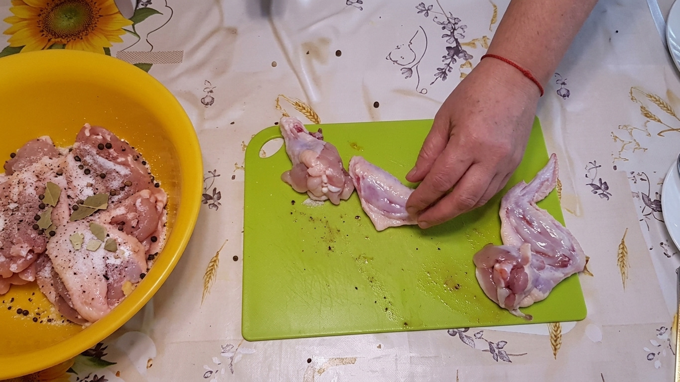 Каструля із шматочками курки, посипаними сіллю, лавровим листом і перцем