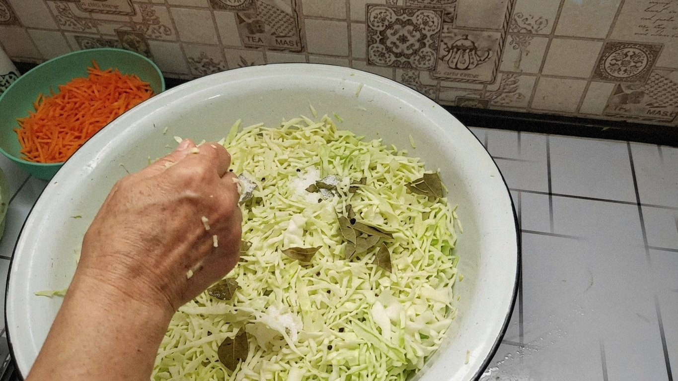 Шматочки капусти замішуються з сіллю та цукром, виділяється сік.