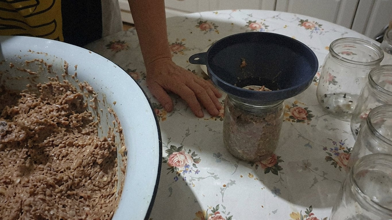Стерилізовані банки стоять на столі, всередині видно лавровий лист та чорний перець.