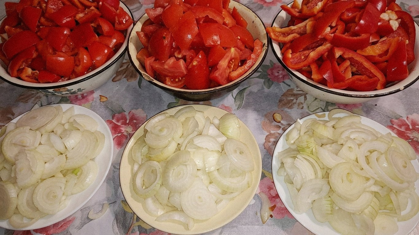 цибуля смажиться у великій сковороді, на ній лежать шматочки болгарського перцю