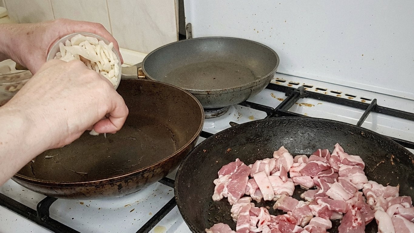 золотиста цибуля смажиться на сковороді, в середині з'являється морква
