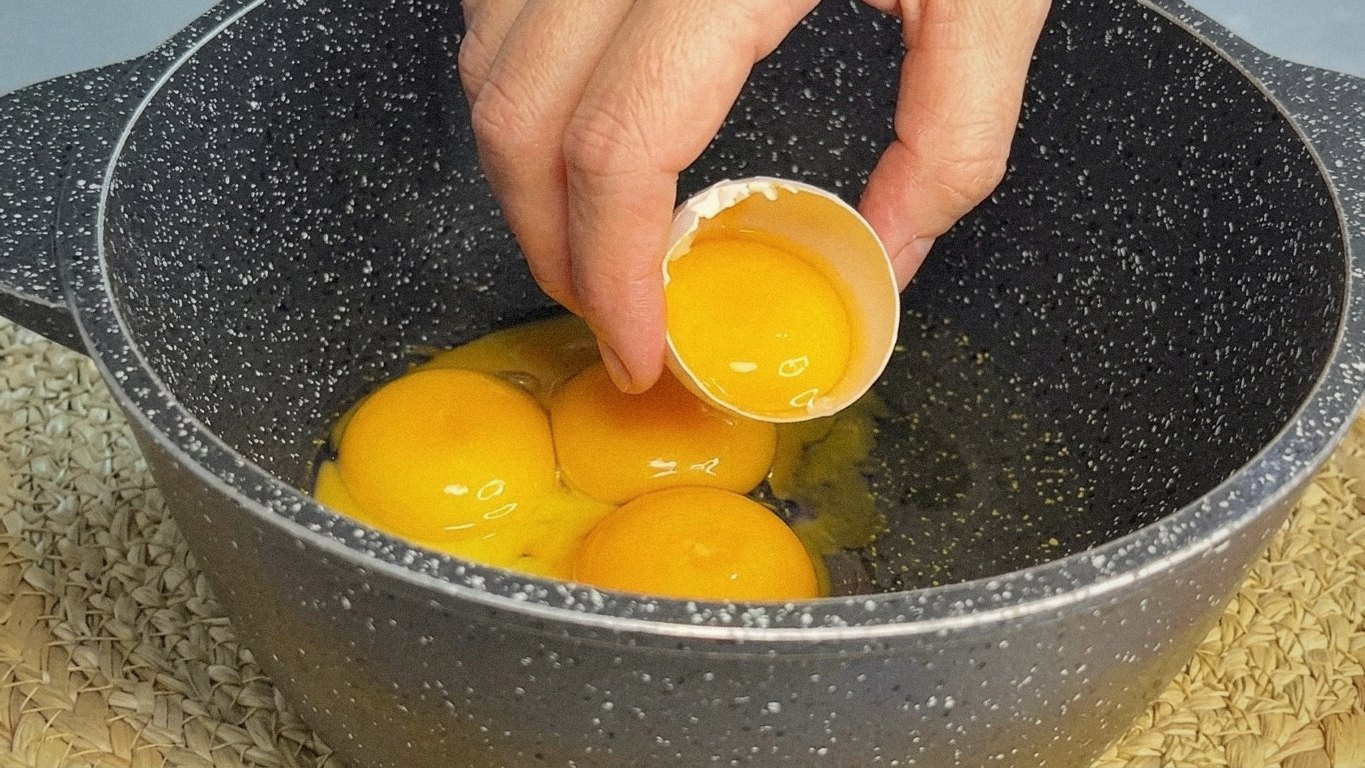 великі білі піки з білкової маси у металевій мисці, міксер в руках