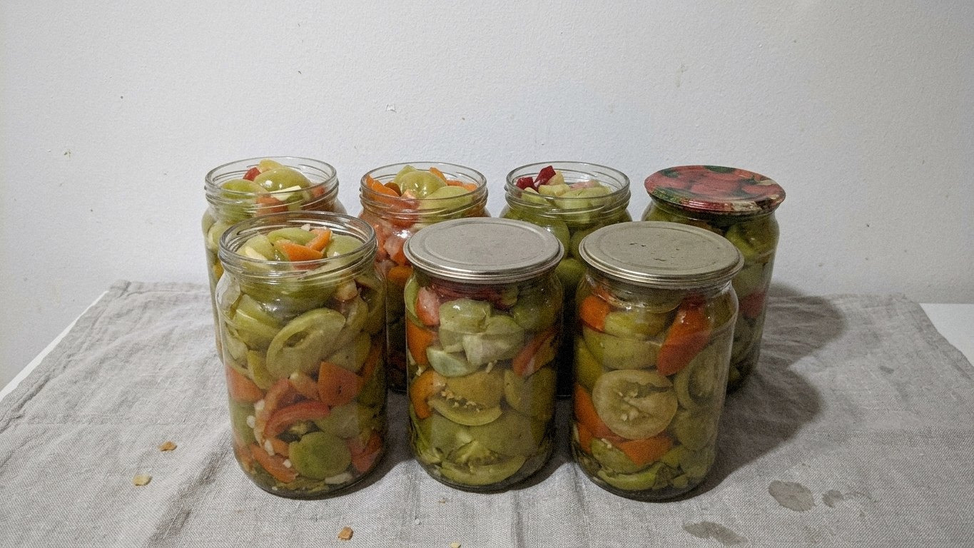 готові банки з зеленими помідорами, що охололи, на столі